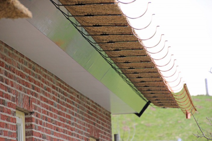 koperen goot onder rieten dak