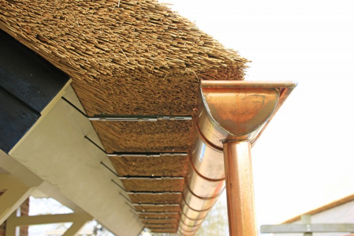 koperen goot onder het rieten dak